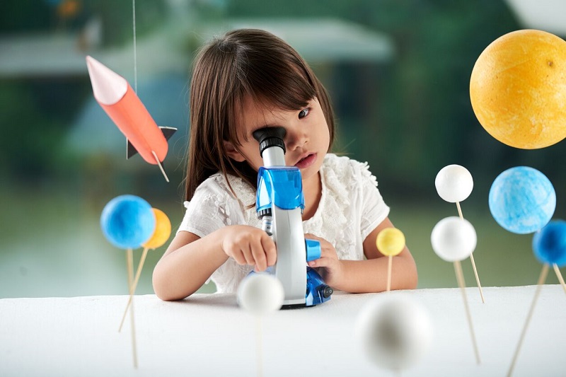 Child studying space science with planets