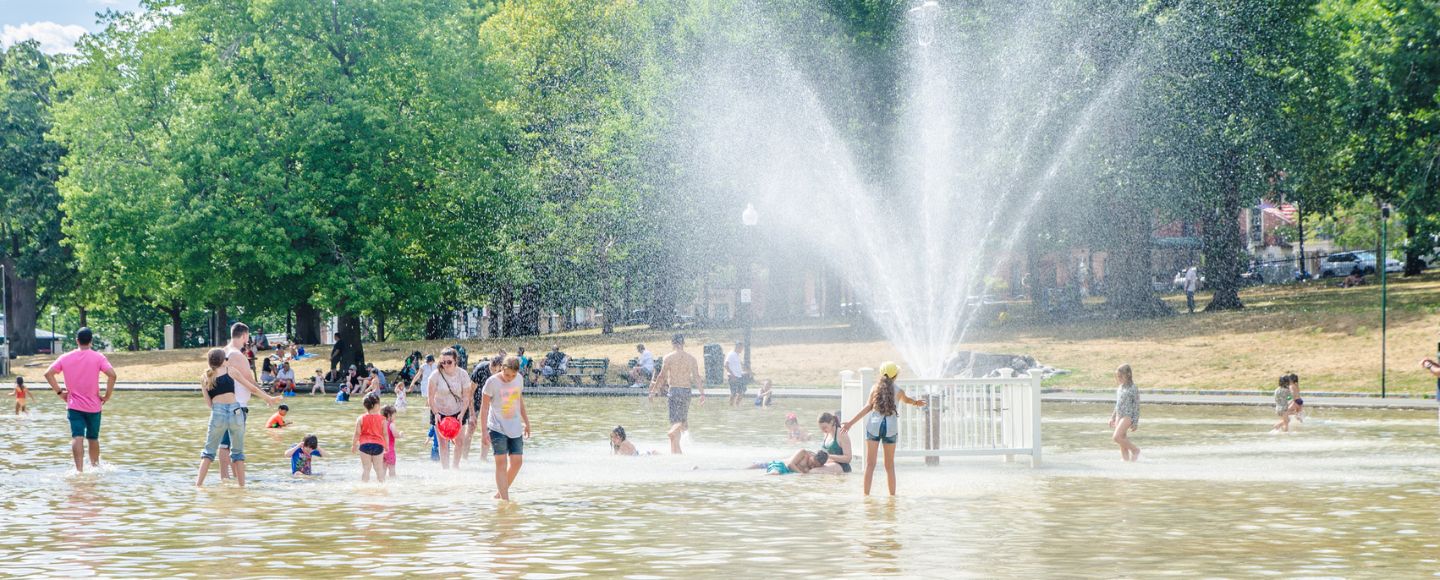 Boston Common Frog Pond crowded with people during heatwave on a summer day